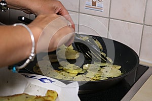 Woman reparing sliced potatoes in a bowl