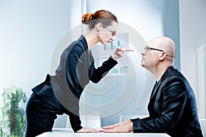 Woman reproaching man at work