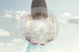 Woman resembling an angel guards a small cloud in her hands photo