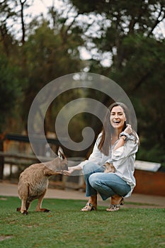 Woman at a reserve is playing with a kangaroo