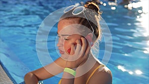 Woman in the resort at swimming pool with smartphone. She using her cell phone