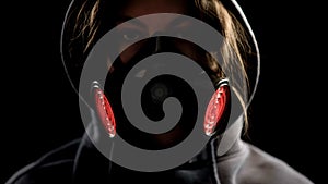 Woman in respirator on dark background, protection from gas attack, closeup