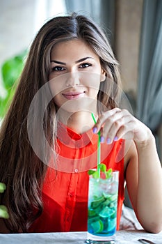 Woman in restaurant is drinking cocktail