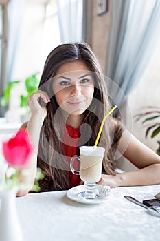 A woman in a restaurant is drinking cocktail