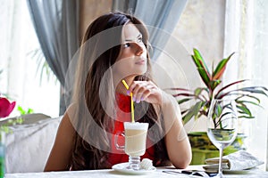 Woman in restaurant is drinking cocktail