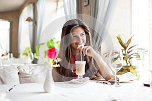 A woman in a restaurant is drinking cocktail