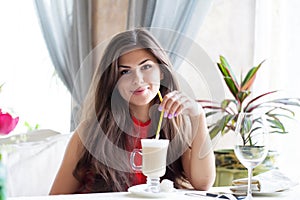 A woman in a restaurant is drinking cocktail