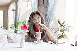 A woman in a restaurant is drinking cocktail