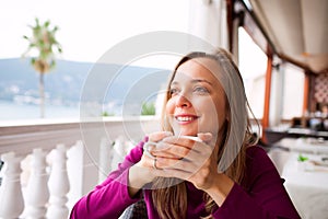 Woman in a restaurant is drinking coffee