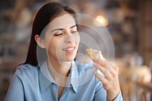 Woman in a restaurant eating bakery