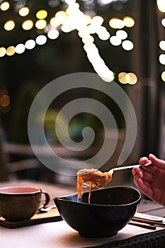 woman in a restaurant on the terrace eating rice noodles. ramen in a plate, thai food