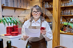 Woman restaurant worker with an order form, smartphone, ordering delivery