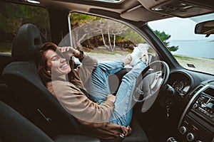 woman resting in car parked at sea beach