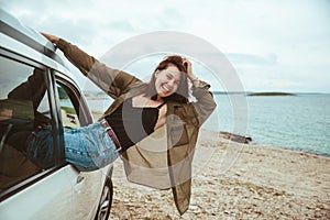 woman resting in car parked at sea beach