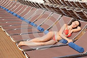 Woman is resting on chaise lounge