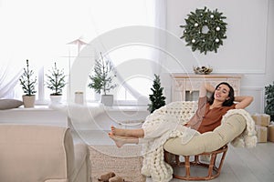 Woman resting in comfortable papasan chair at home