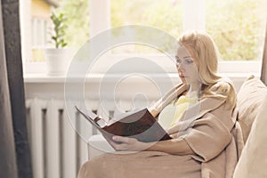 Woman resting on the couch and read a book