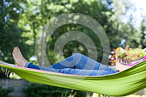 Woman resting with drink on hammock