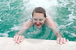 Woman resting in jacuzzi of pool