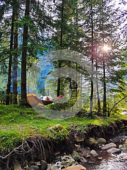 woman resting laying on hammock at camping site