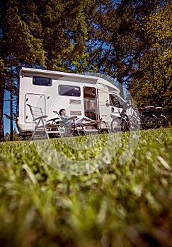 Woman resting near motorhomes in nature. Family vacation travel, holiday trip in motorhome RV, Caravan car Vacation.