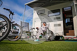 Woman resting near motorhomes in nature. Family vacation travel, holiday trip in motorhome RV, Caravan car Vacation.