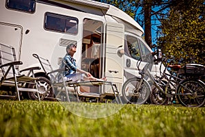 Woman resting near motorhomes in nature. Family vacation travel, holiday trip in motorhome RV, Caravan car Vacation.