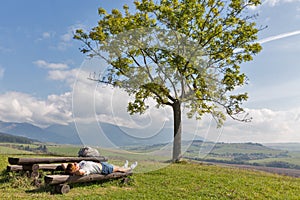 Žena odpočívá na letním kopci poblíž Liptovského Trnovce, Slovensko.