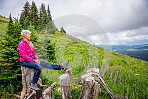 Woman Resting on a Tree Stump during a Hike photo