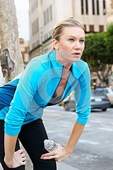 Woman Resting Whilst Running Along Urban Street