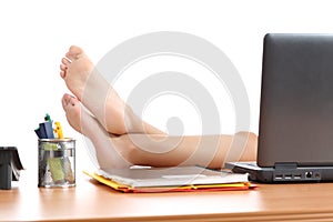 Woman resting at work with the feet over the office table