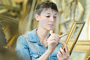 woman restoring antique frame