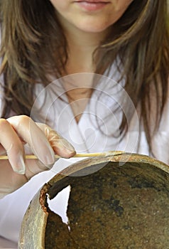 Woman restoring a prehistoric vessel