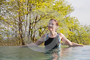 The woman is rests in outdoor pool