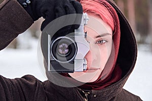 Woman with retro camera in winter forest