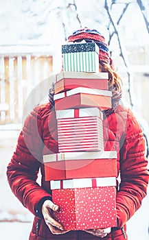 woman returning home from shopping holding pile of christmas present boxes