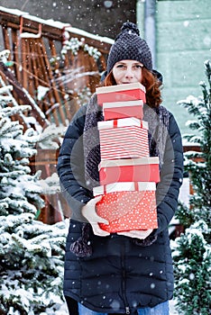 woman returning home from shopping holding pile of christmas present boxes