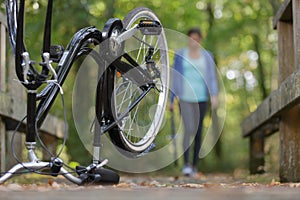 woman returning to upended bicycle