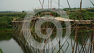 The woman returns home after a day out to work on a bamboo bridge