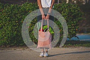 Woman with reusable eco bag with vegetables. Plant based vegan diet shopping.