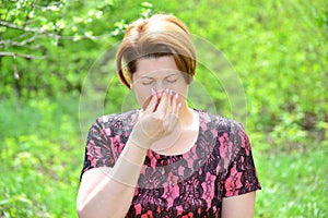 Woman with rhinitis in summer park