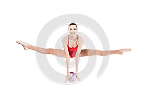 Woman rhythmic gymnast jumping with ball and looking at camera