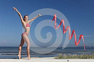 Woman rhythmic gymnast with red ribbon