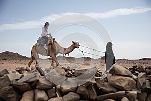 Woman ride in camel desert location