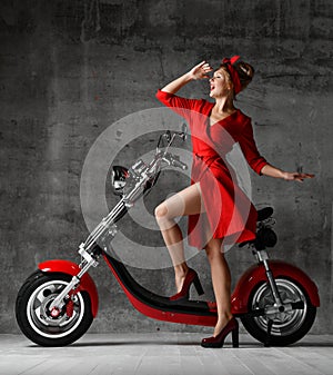 Woman ride sit on motorcycle bicycle scooter pinup retro style laughing smiling red dress