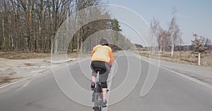 Woman rides on bike. Female cycling on bicycle. Triathlete hard pedaling on bike. Girl in helmet riding outdoor. Triathlon concept