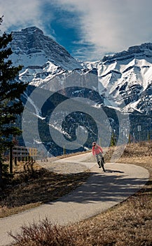 A woman rides a bike on the Legacy Trail, which runs from Canmore to Banff in Alberta, Canada photo
