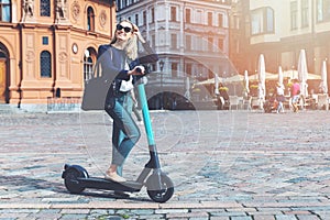 woman rides electric scooter in the city streets. eco friendly transportation