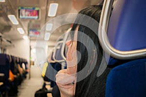 A woman rides on public transport. A girl is sitting in an electric train chair. The view from the back.The passenger is traveling