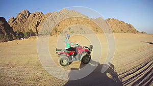 Woman Rides a Quad Bike in the Desert of Egypt